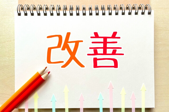改善を示す赤い文字とノート